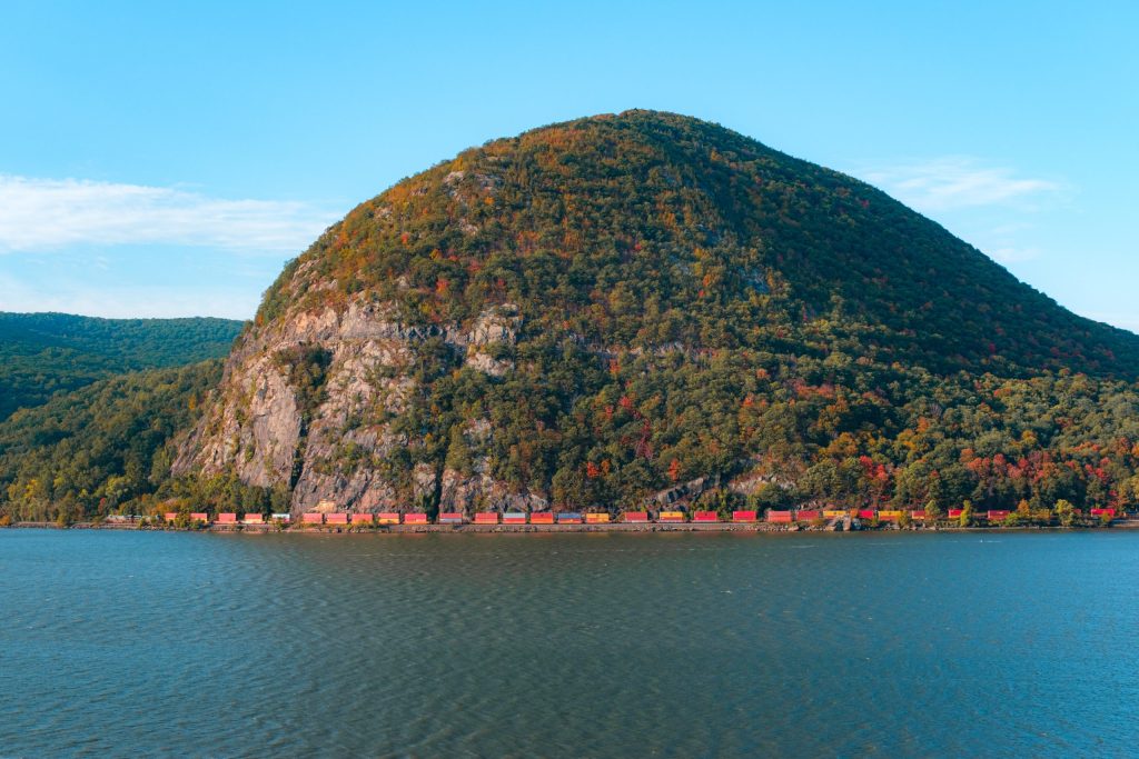 Train Below Storm King Tranquil image of a cargo train passing below Storm King Mountain along the Hudson River