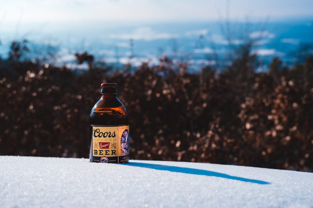Coors in the Snow A bottle of Coors Banquet beer displayed in fresh snow atop a mountain.