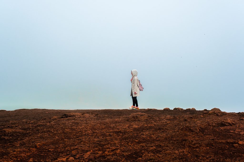 The Hiker A woman standing on rocky terrain starkly contrasting the sky