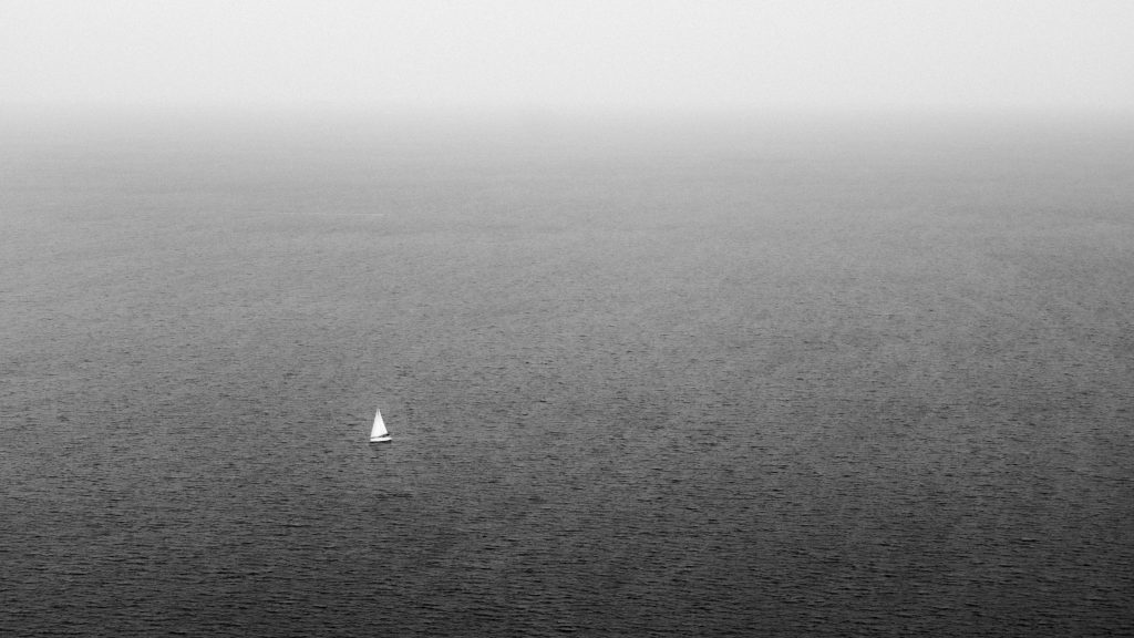 Lonely Sailboat A small sailboat in an open expanse of water